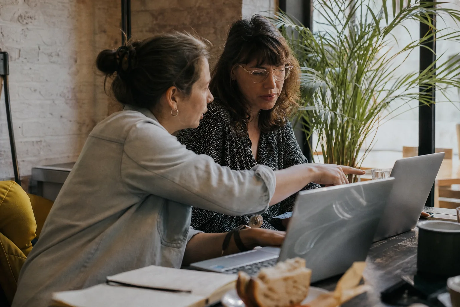 Two bookkeepers comparing receipt tools side by side on their laptops