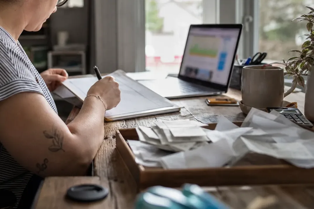 Receipts on a desk next to a laptop where scanned documents are reviewed